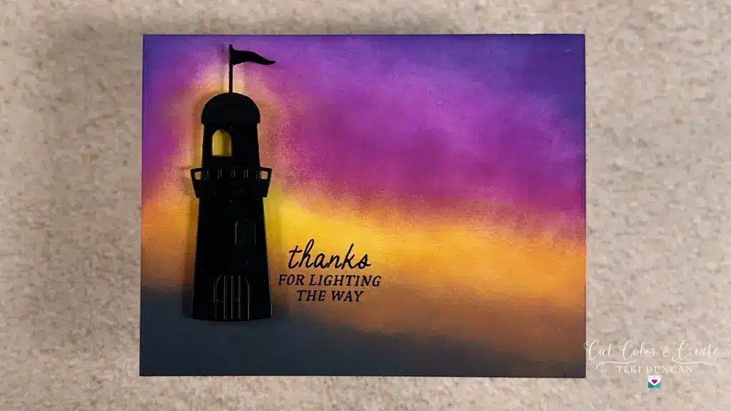 A silhouette of a lighthouse against a vibrant sunset sky with the text "thanks for lighting the way" printed beside it—perfect for Nautical Cards or Club Kits. Create using Spellbinders June '25 Club kits.