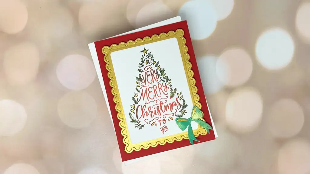 A Christmas card with a gold scalloped border, a tree design made of festive text reading "Very Merry Christmas to you," and a green ribbon bow on the bottom right corner.