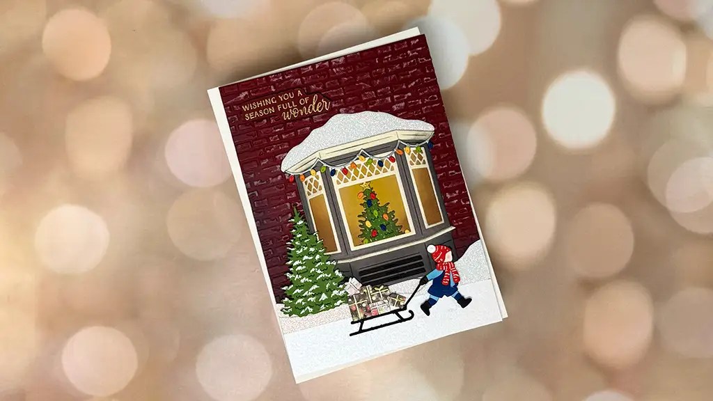 A holiday greeting card featuring an illustrated window, a Christmas tree, and a child pulling a sled in the snow. Perfect to inspire others on how to make greeting cards filled with wonder for the season.