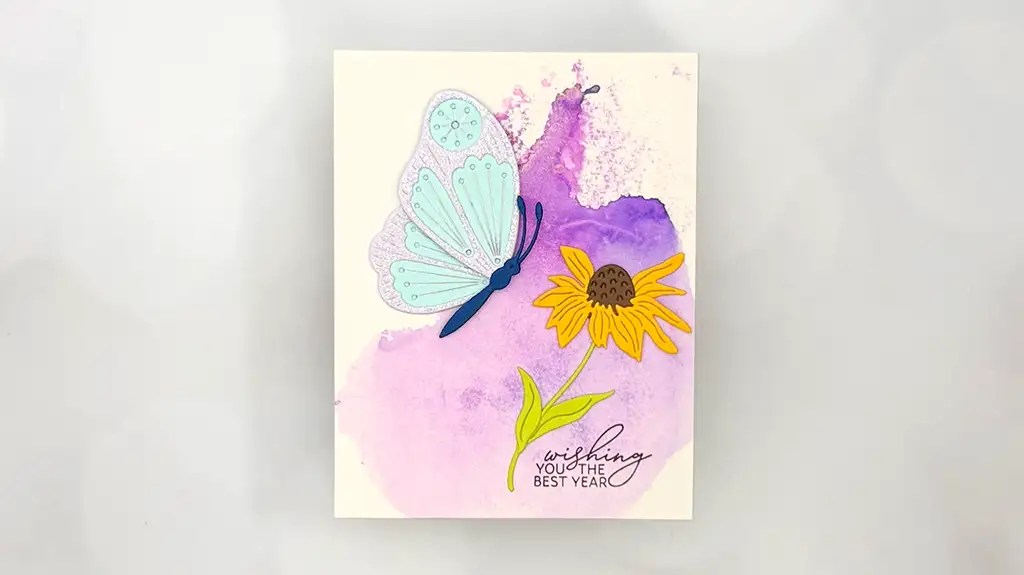 A stunning card featuring a blue butterfly, yellow flower, and the text "wishing you the best year" on a purple watercolor background—perfect for fans of Club Kit Cards.