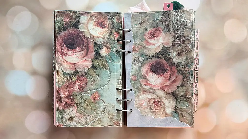 An open ring bound wedding album displays pages decorated with large vintage style pink and white roses against a soft blurred background evoking the timeless romance of a love story wedding album