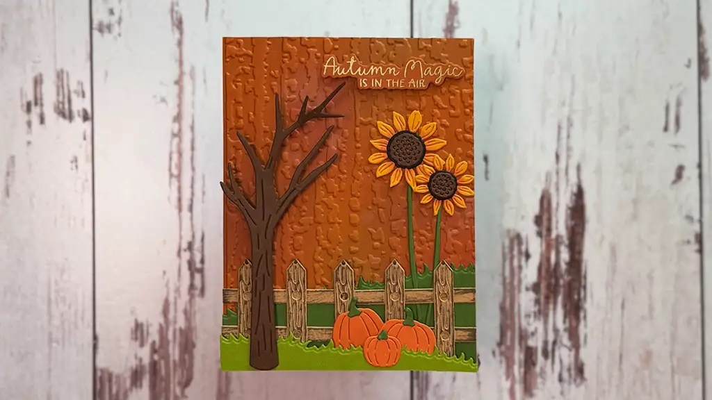 Handmade magical autumn card featuring a bare tree two sunflowers pumpkins a wooden fence and autumn magic is in the air text on an orange textured backgroundperfect inspiration if youre looking for how to make autumn cards