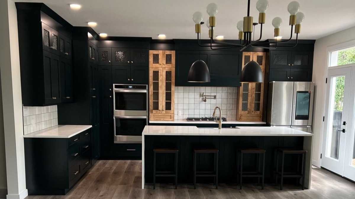 A kitchen with black painted cabinet doors and two stained wood frames. Cutting Edge is one of many cabinet door suppliers in Canada.