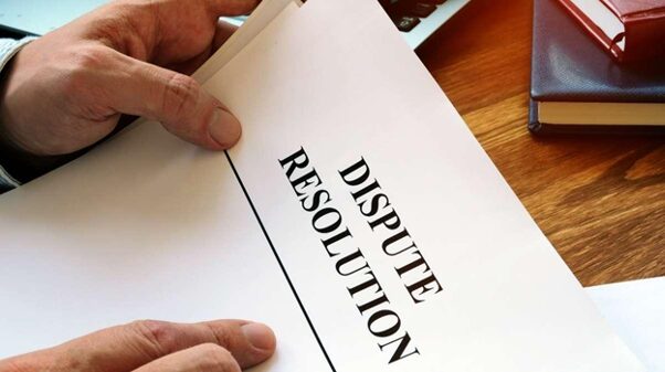 A man holding a document titled Dispute Resolution. While you can dispute accessorial charges, carriers make the final decision and may not reverse the fees.