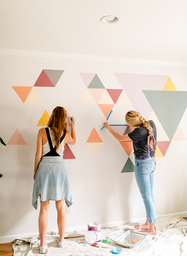 Using caulk · place painters tape on the wall, about 1/8″ down from the ceiling. A DIY Geometric Wall Mural with BEHR Paint - Inspired By This