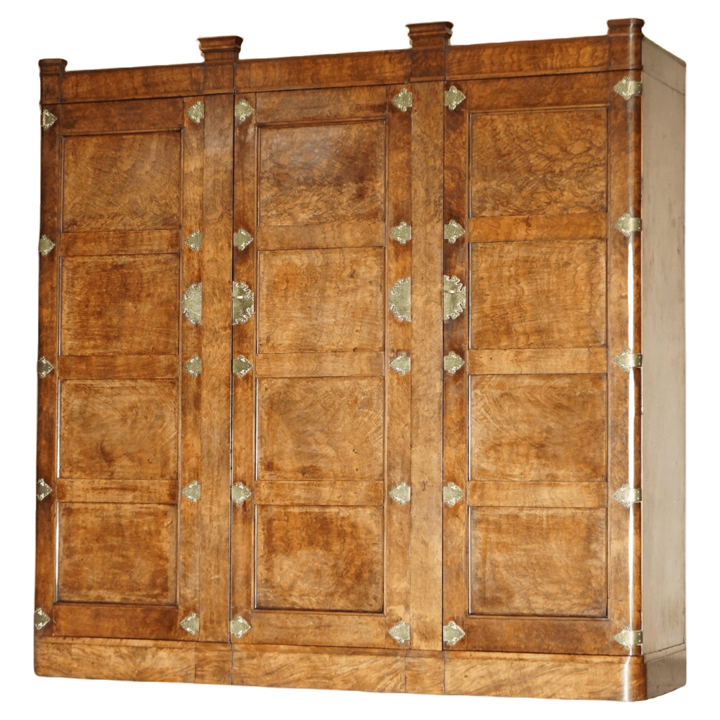Vintage brown wood wardrobe with three doors and intricate detailing.