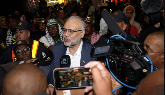 سفير جنوب إفريقيا السابق لدى الولايات المتحدة إبراهيم رسول (وسط) لدى وصوله إلى مطار كيب تاون في 23 مارس 2025