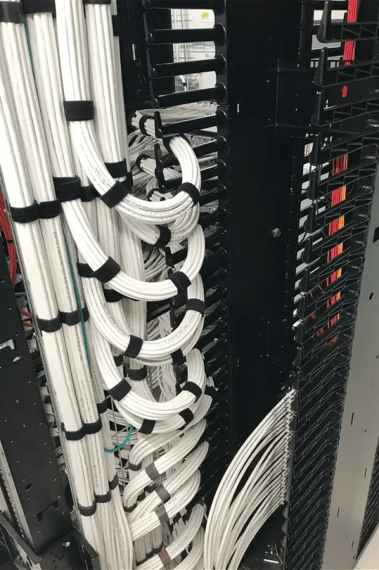 Patchkast met gestructureerde koper netwerkbekabeling. Netjes gebundeld per patchpaneel.