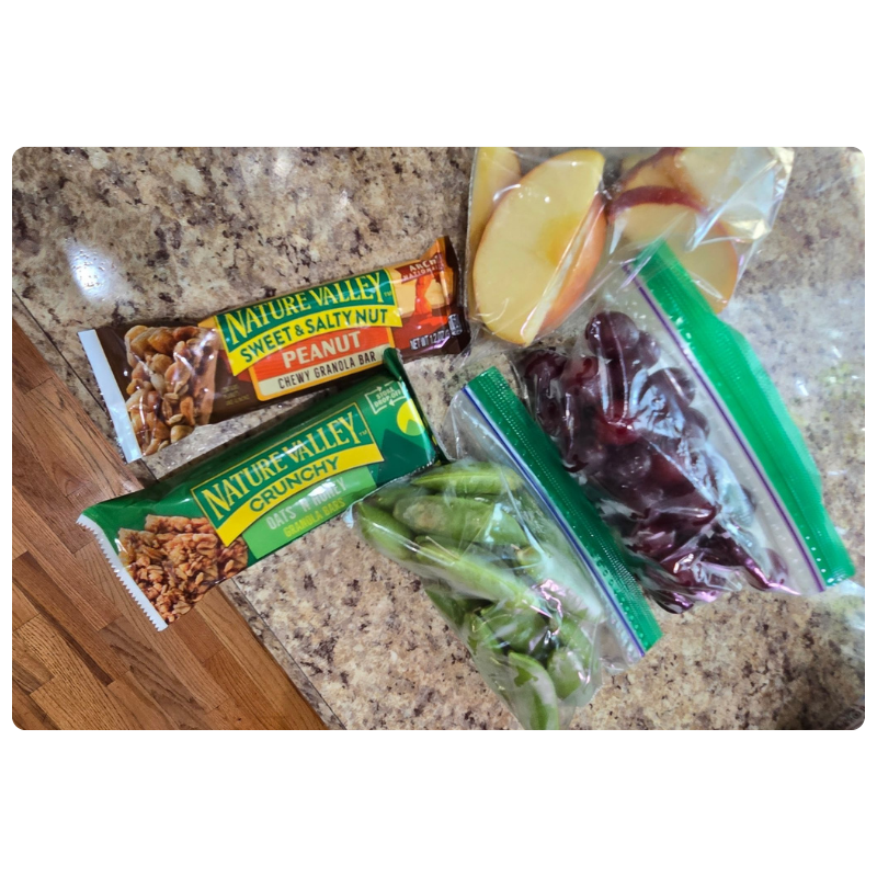 Healthy travel snacks packed for a family vacation, including fruit and granola bars, to help make family travel easier and stress-free.