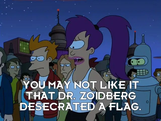 Leela, a purple-haired woman in a tank top, gestures passionately toward Nixon’s head-in-a-jar. A crowd stands behind her. The subtitles say, “YOU MAY NOT LIKE IT THAT DR. ZOIDBERG DESECRATED A FLAG.”