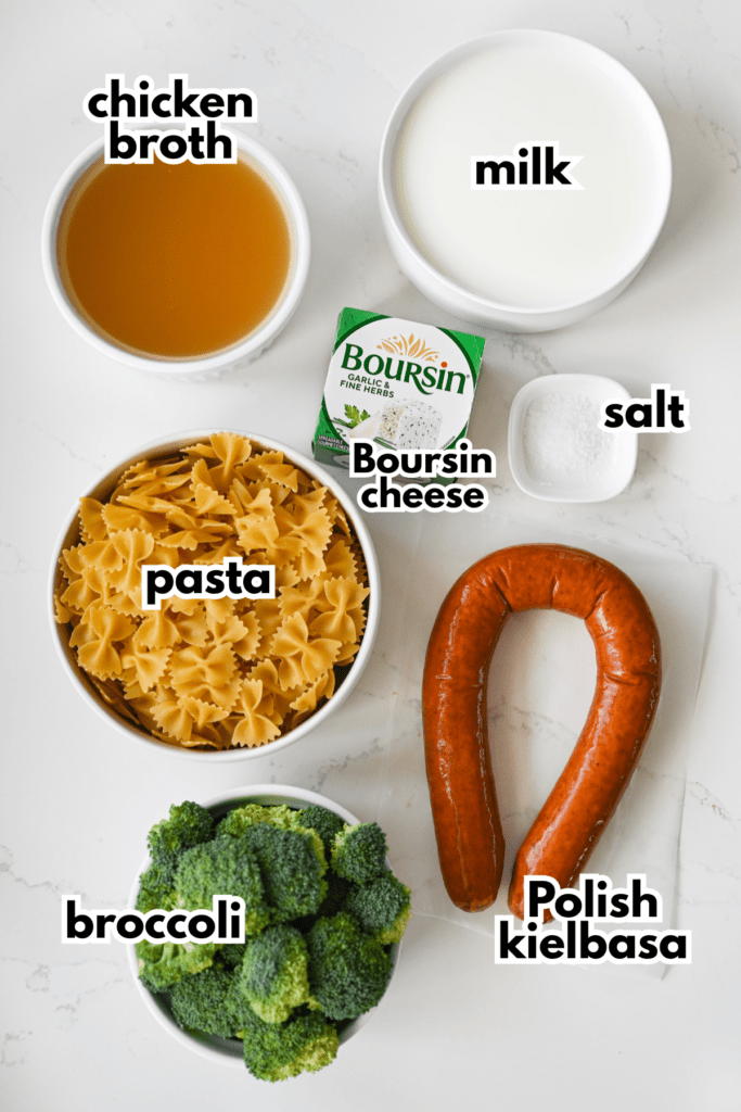 The ingredients needed to make a dump and bake pasta. The labeled ingredients are setting on a white quartz countertop.