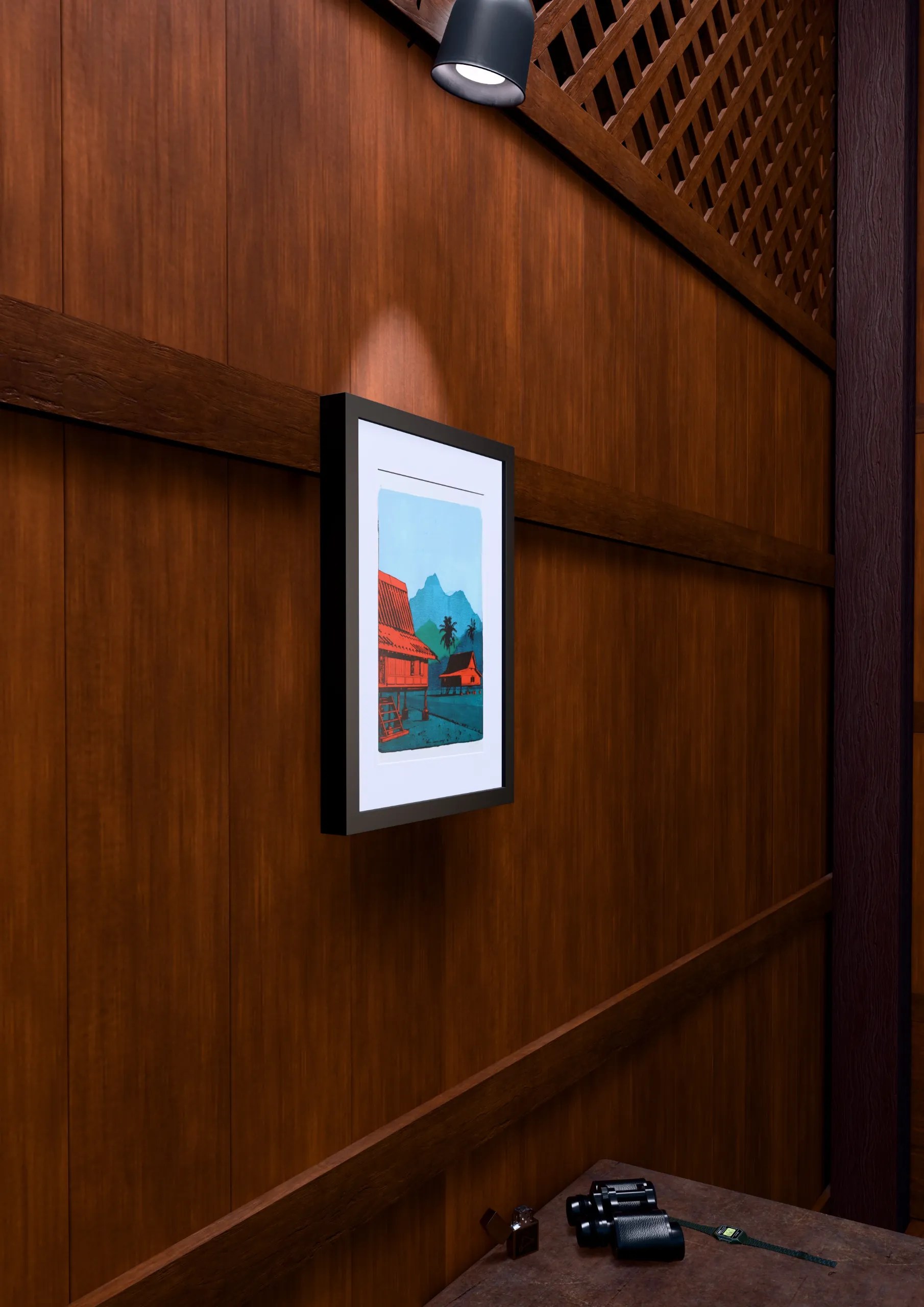 Two Houses Study #2, gel plate monotype by Daniel Arendzen, framed on a wooden wall under a spotlight, seen from the side, with binoculars, a watch and a lighter on a table below. The room is a Blender render of the interior of the same traditional Malaysian house shown in the print.
