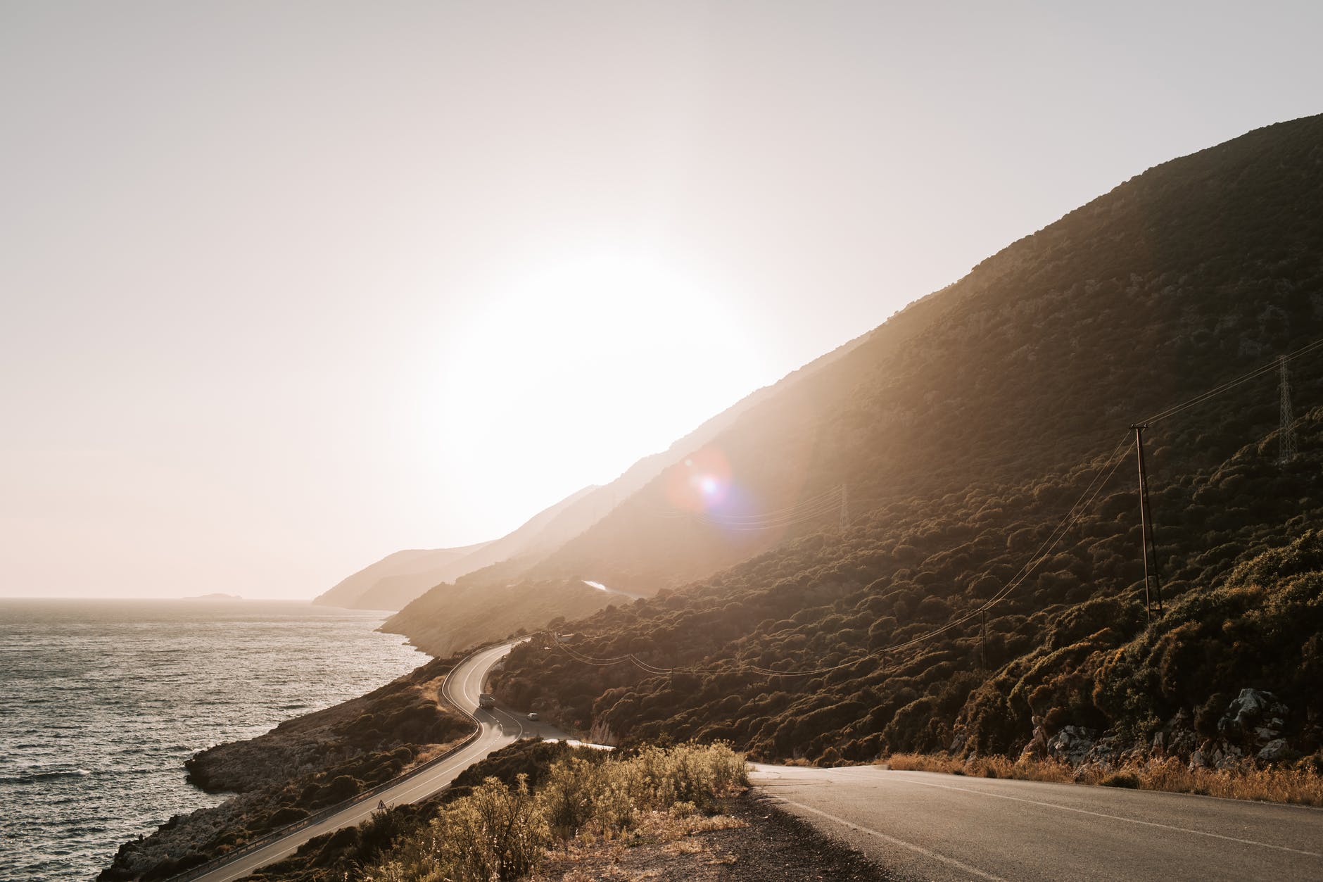 coastal road with view of sunset over the mountain