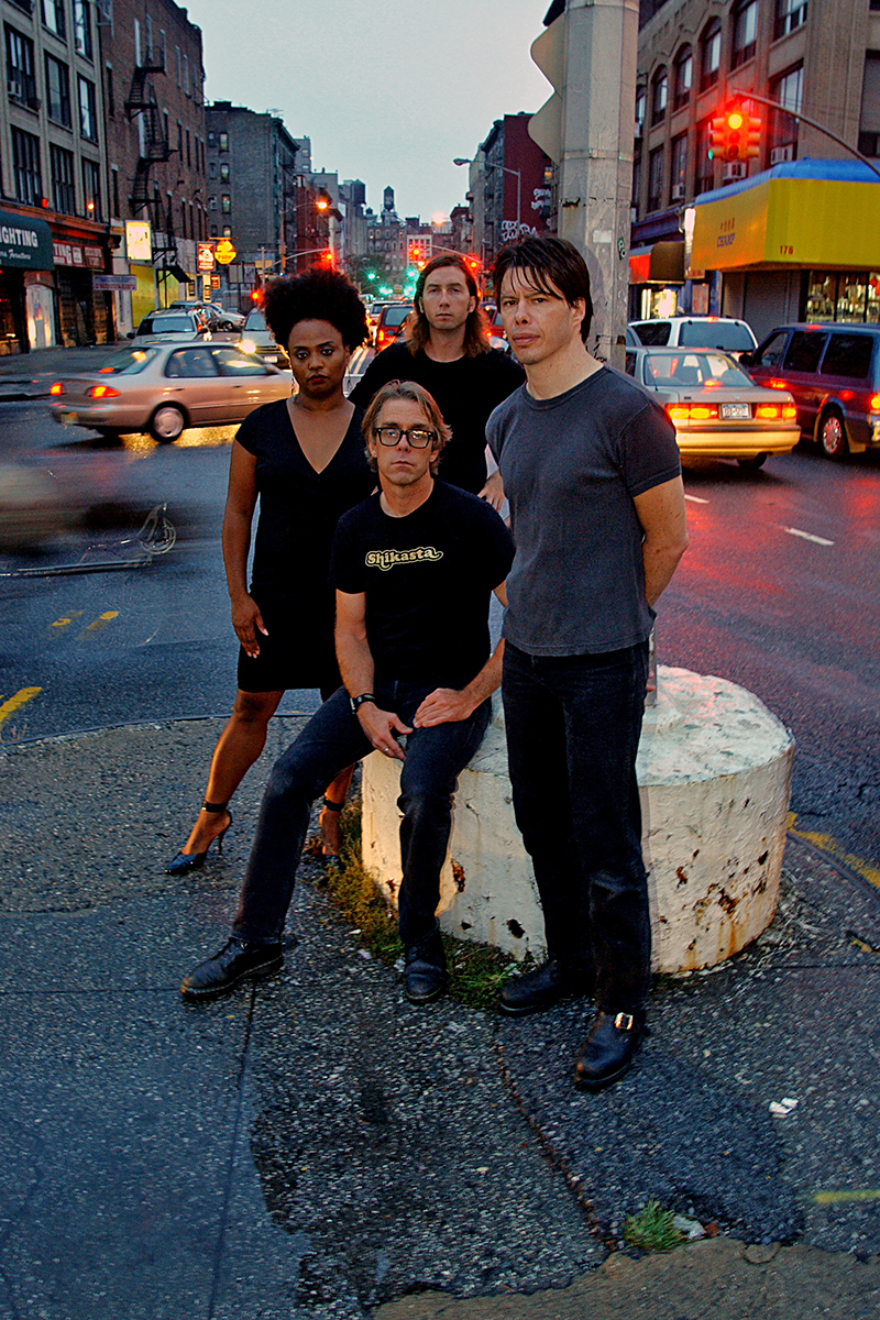 Portrait du groupe The Bellrays, musiciens en extérieur, attitude rock, éclairage contrasté, style années 2000