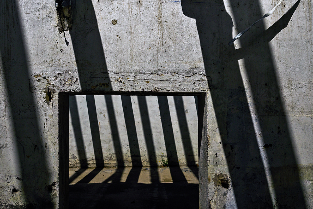 Jeu de lumière dans un entrepôt en rénovation à Béziers, avec des motifs géométriques projetés par des poutres.