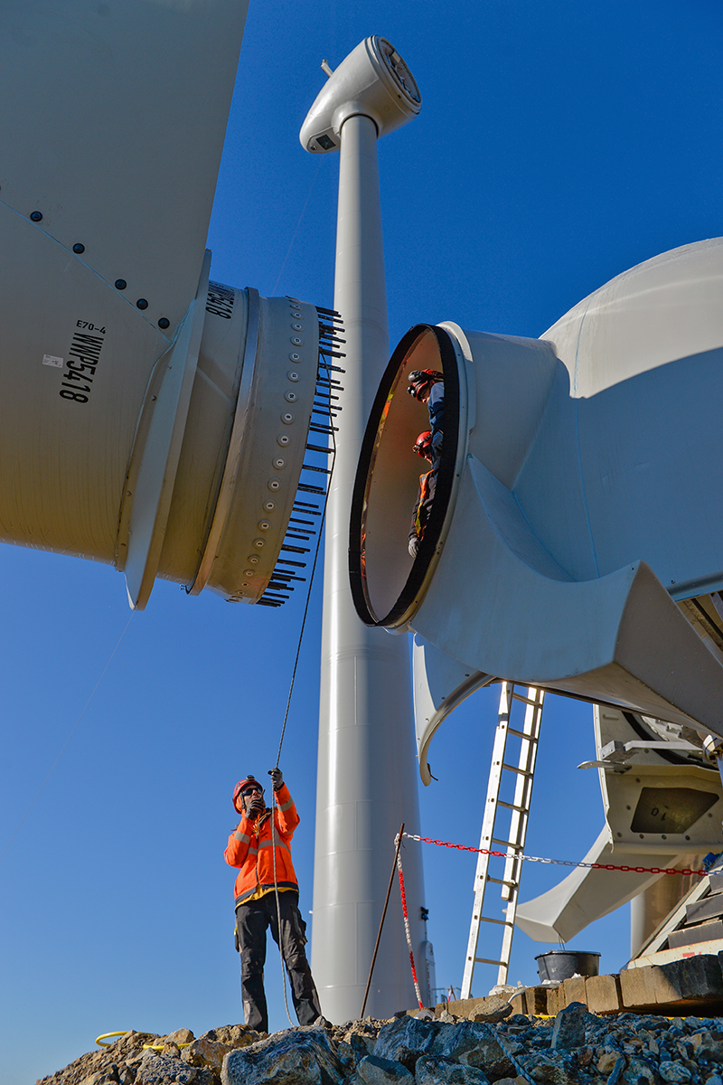 Suivi de chantier : Ouvrier au sol et à l'intérieur de la nacelle d'une éolienne lors de l'assemblage pour le projet de Sepale à Béziers.