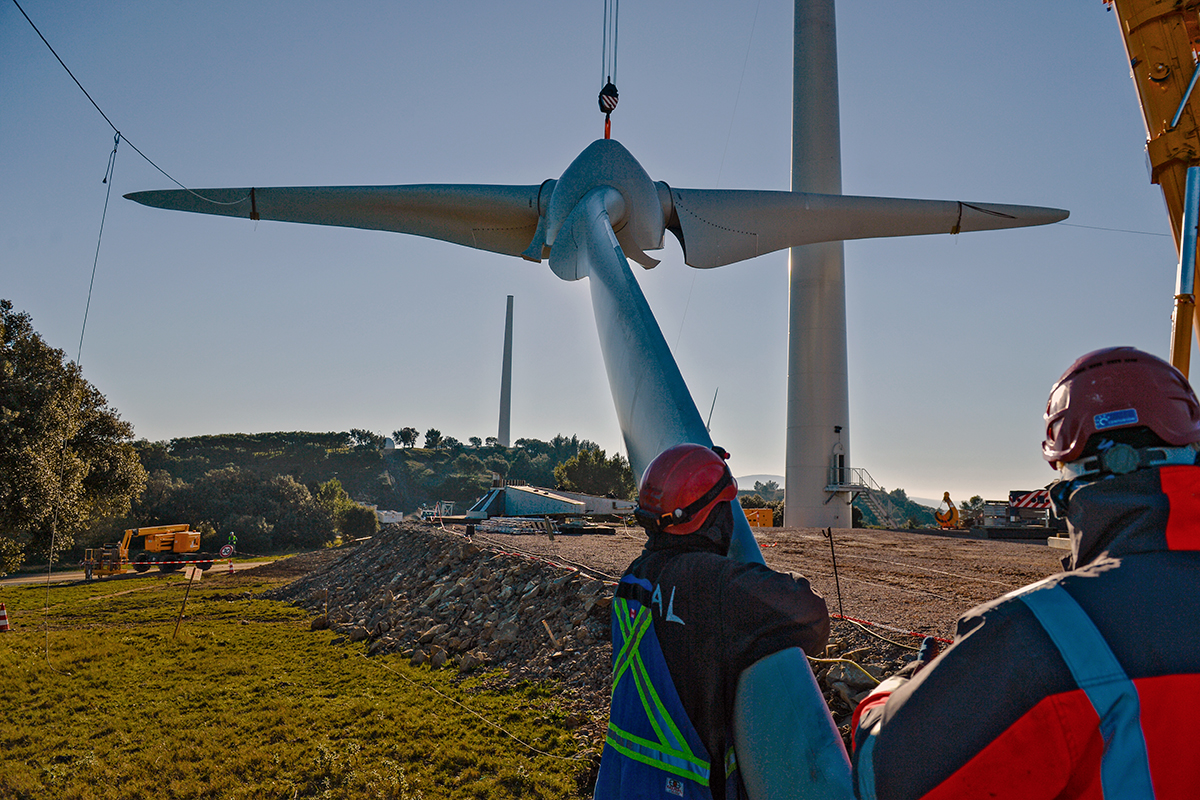 Suivi de chantier : Ouvriers supervisant le levage d'une pale d'éolienne pour le projet de Sepale à Béziers.
