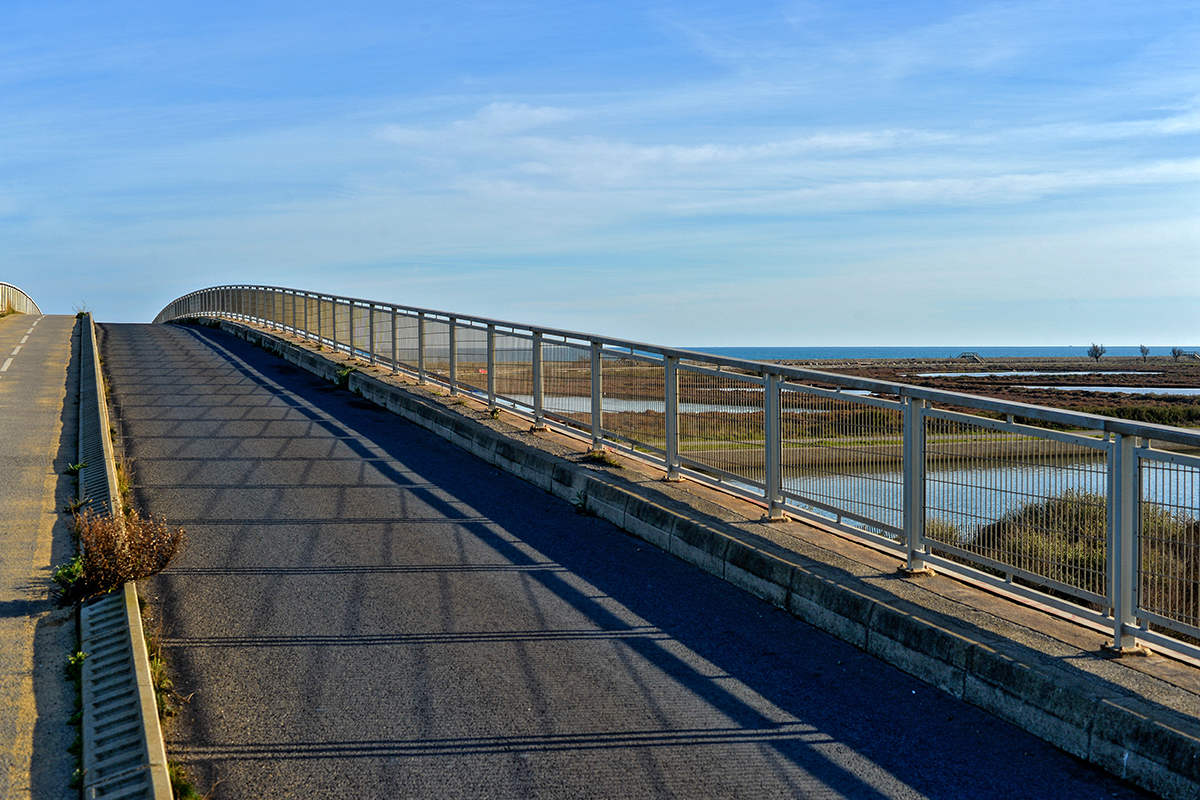 Piste cyclable ou pont piétonnier à Les Aresquiers avec vue sur la mer.