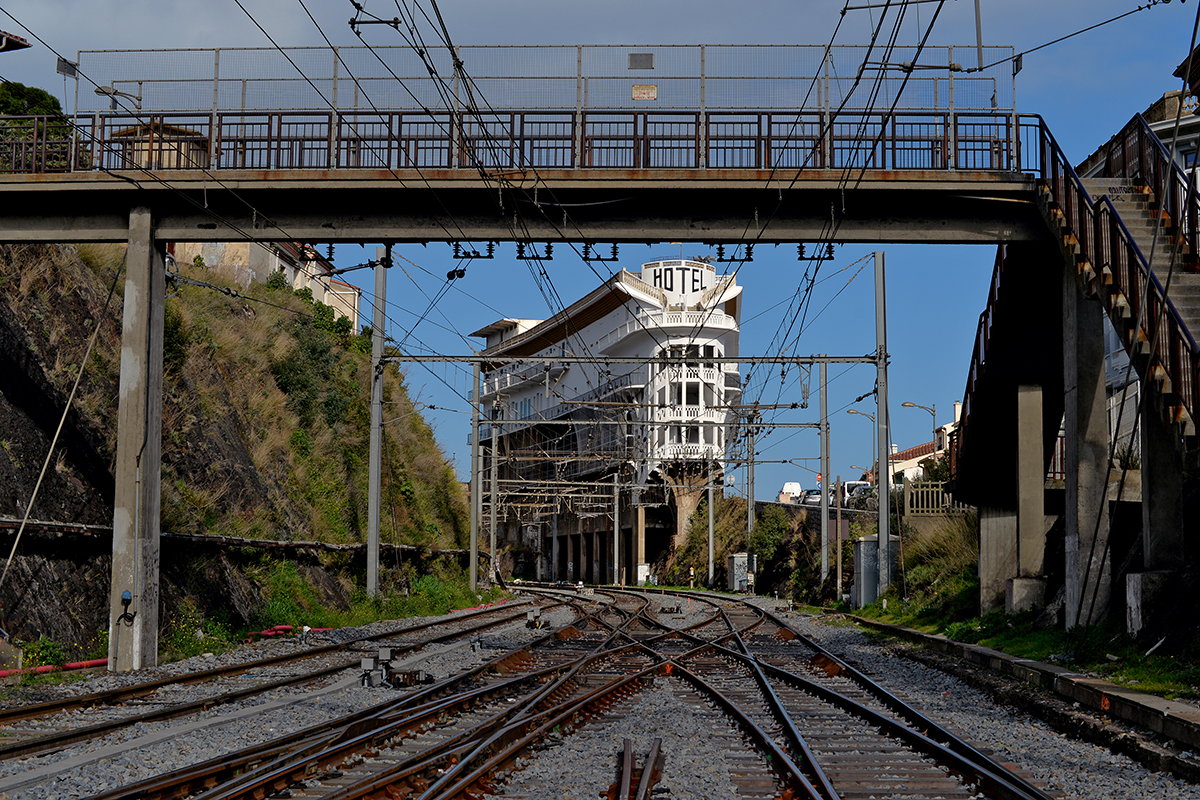 Vue de l'Hôtel Le Belvédère du Rayon Vert à Cerbère, encadrée par des voies ferrées et un pont.