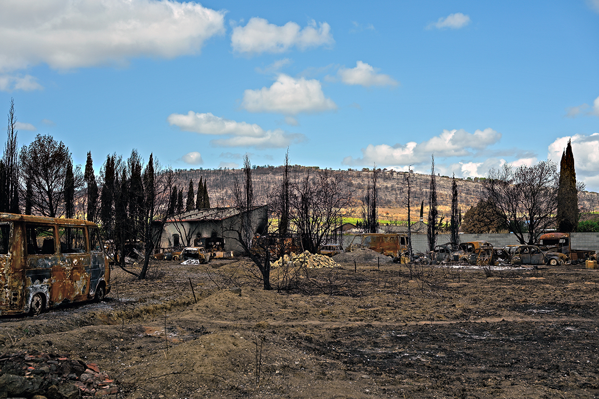 Habitat rural impacté par le feu, vestiges et ruines visibles