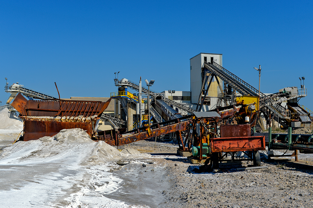 Vue des salins désaffectés à Salin-de-Giraud, avec des structures industrielles et des tas de sel.