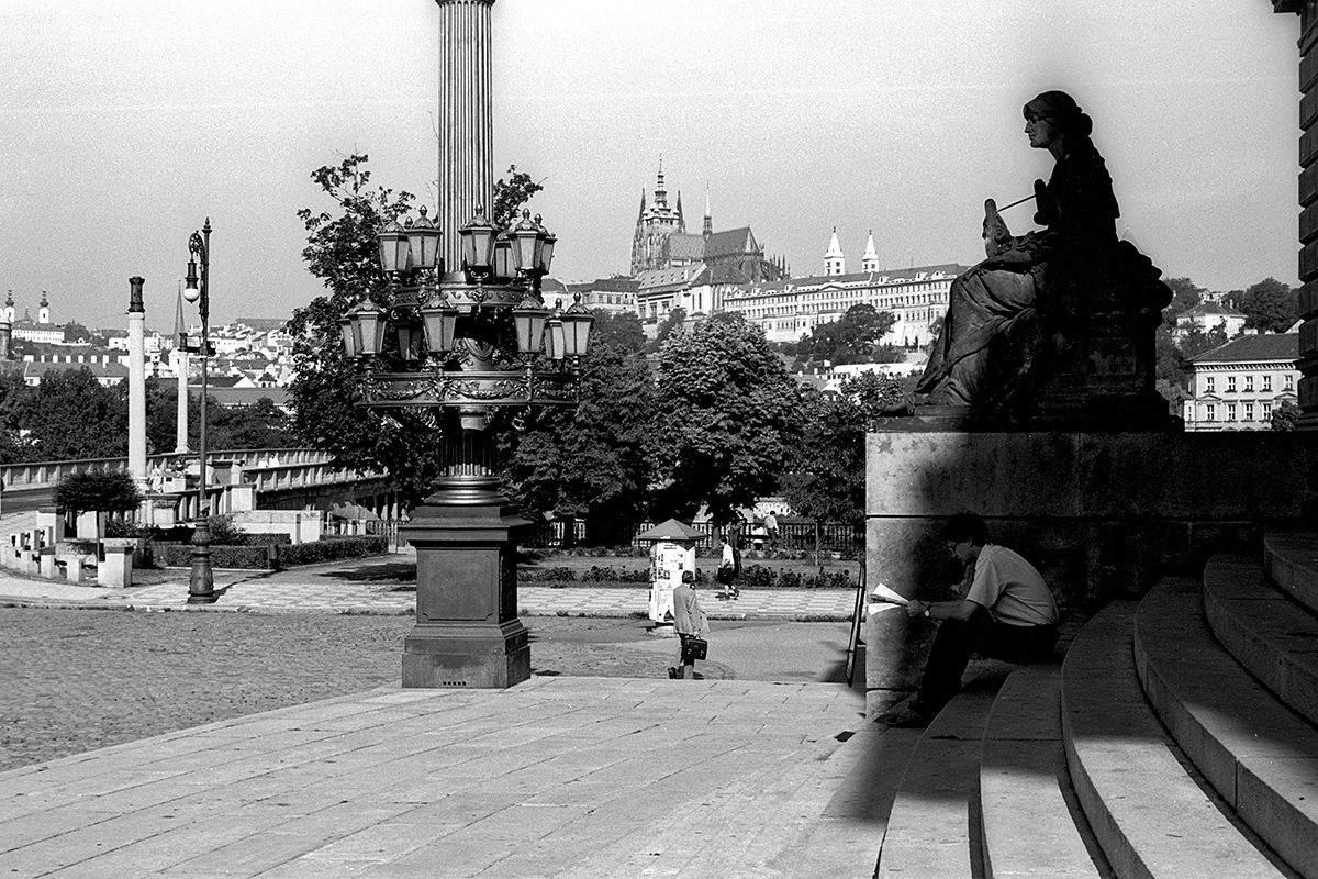 Scène tranquille à Prague à la fin des années 90, avec des statues et une vue sur le château de Prague en arrière-plan.