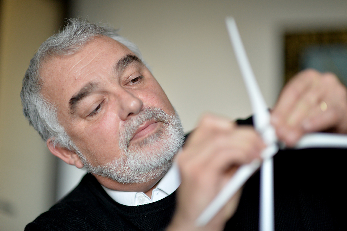Portrait de Jean-Marc Bouchet, fondateur de Quadran, en train de manipuler une maquette d’éolienne