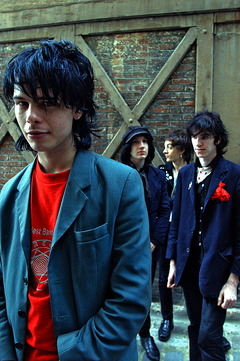 Photo du groupe The Star Spangles posé dans une ruelle en brique, style rock vintage
