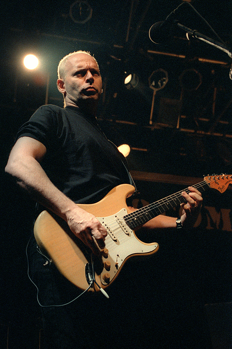 Wayne Kramer sur scène à La Locomotive, jouant de la guitare sous un éclairage dramatique.