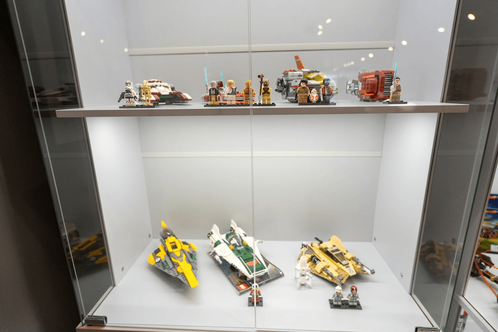 Assembled LEGO sets inside a glass display cabinet