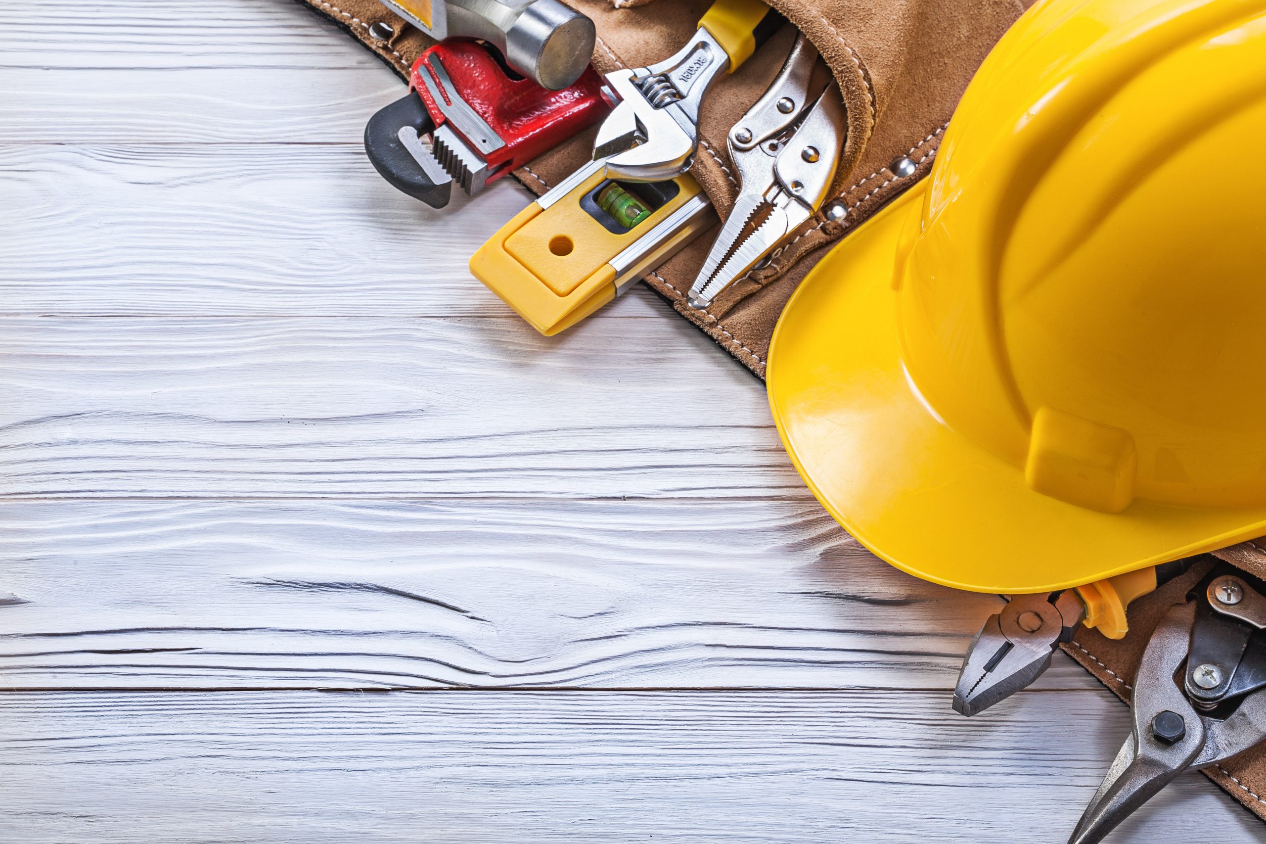 Construction belt hard hat on wooden board maintenance concept.