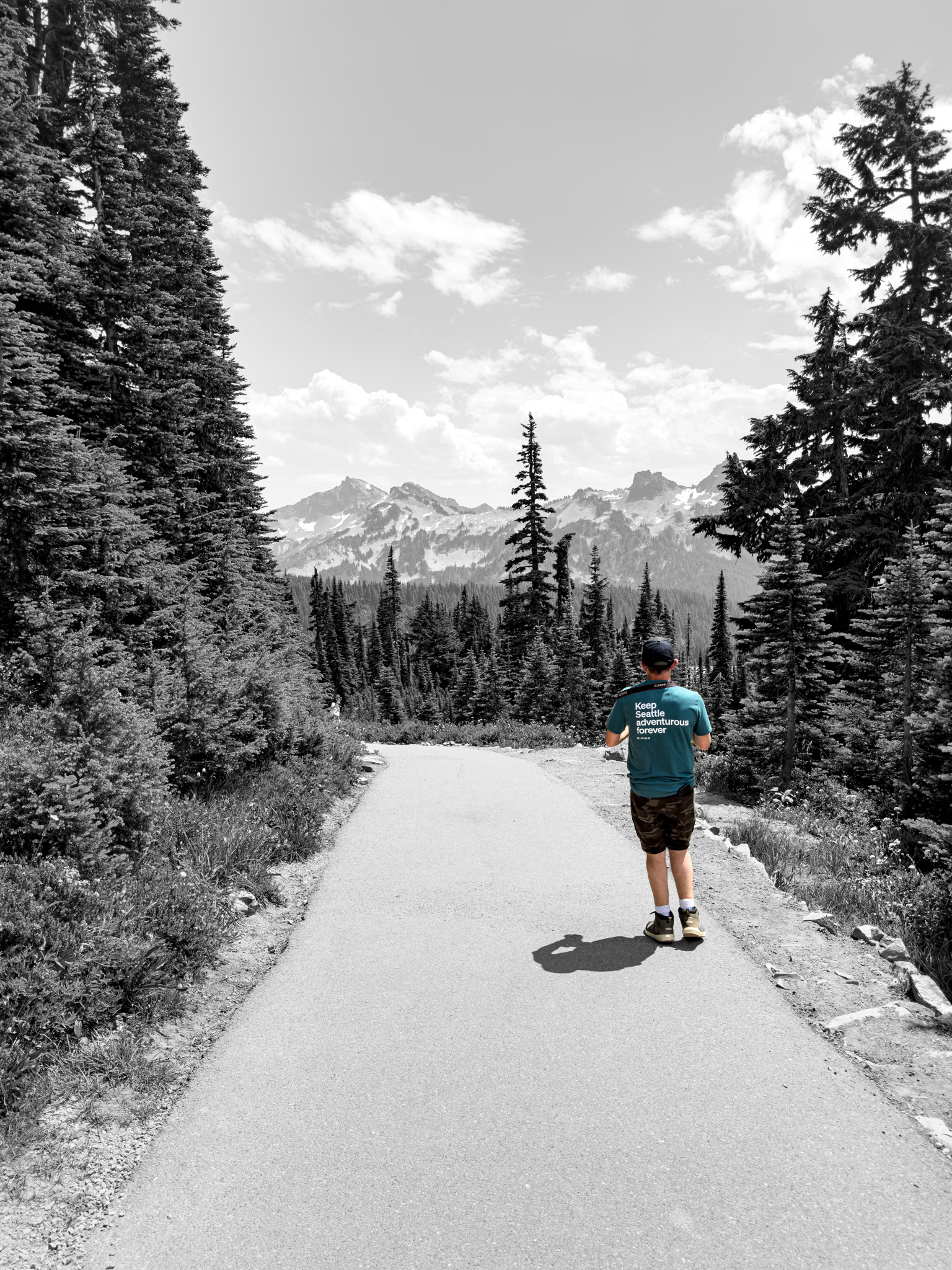 A hiker on the trail with the Tatoosh Range beyond
