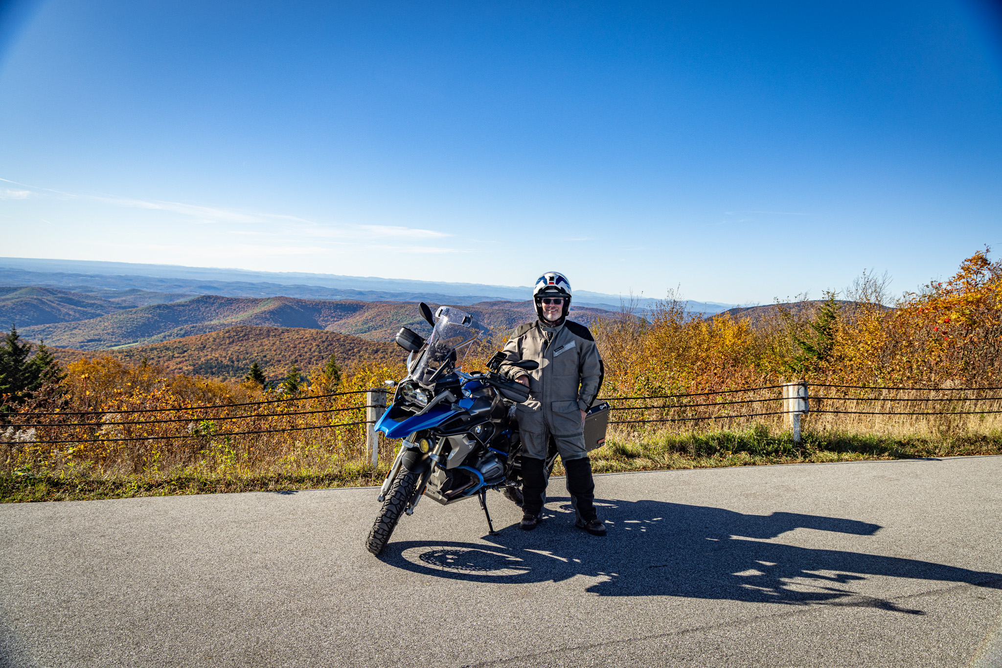 The rider standing beside the GS at the summit overlook