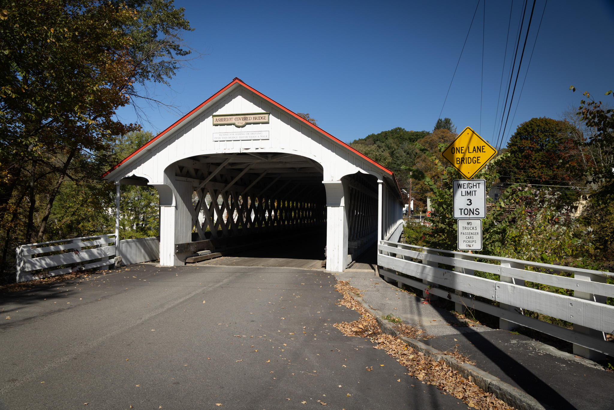 White covered bridge with a weight limit sign at its entrance