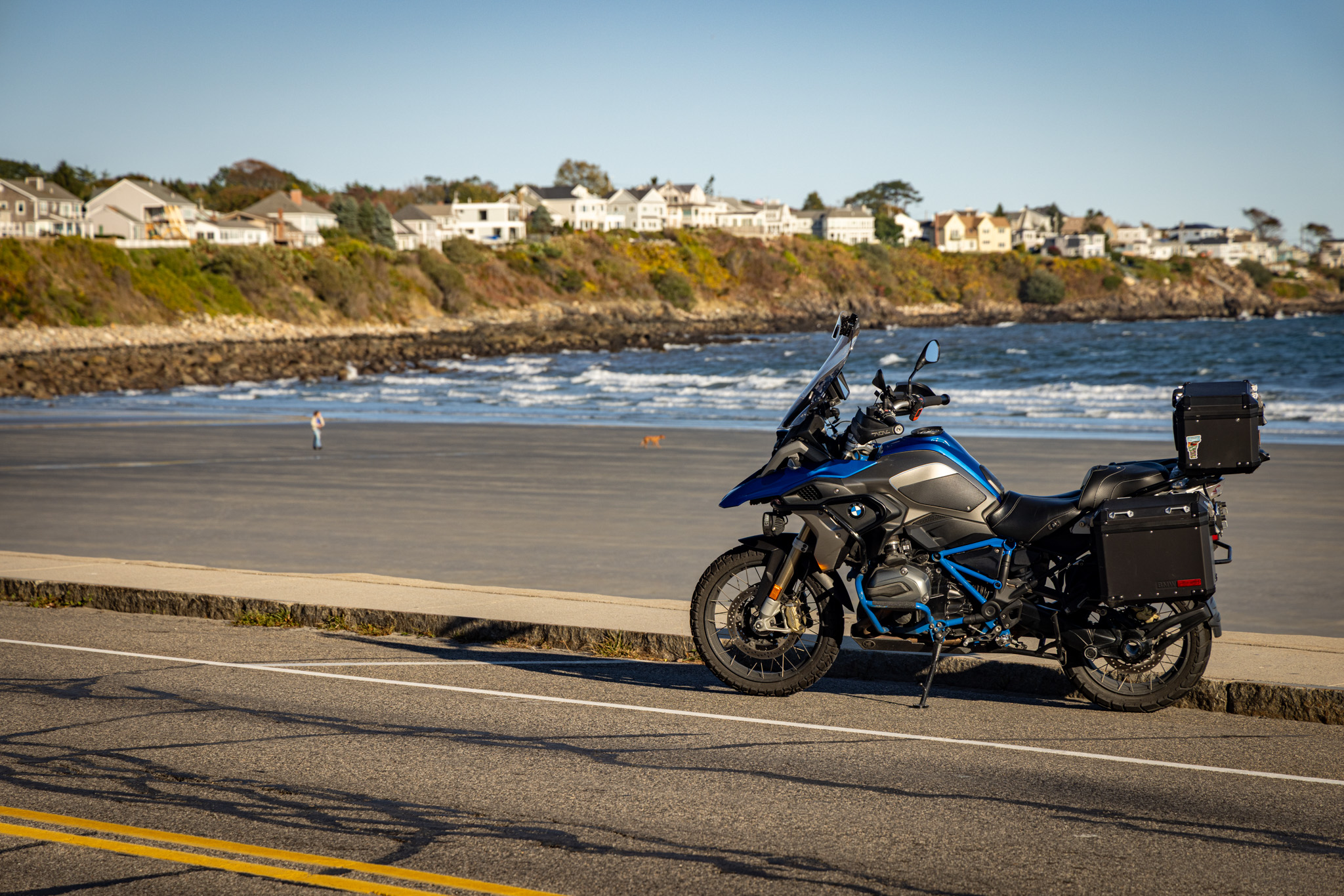 The GS parked on the beach road with houses along the shore behind it