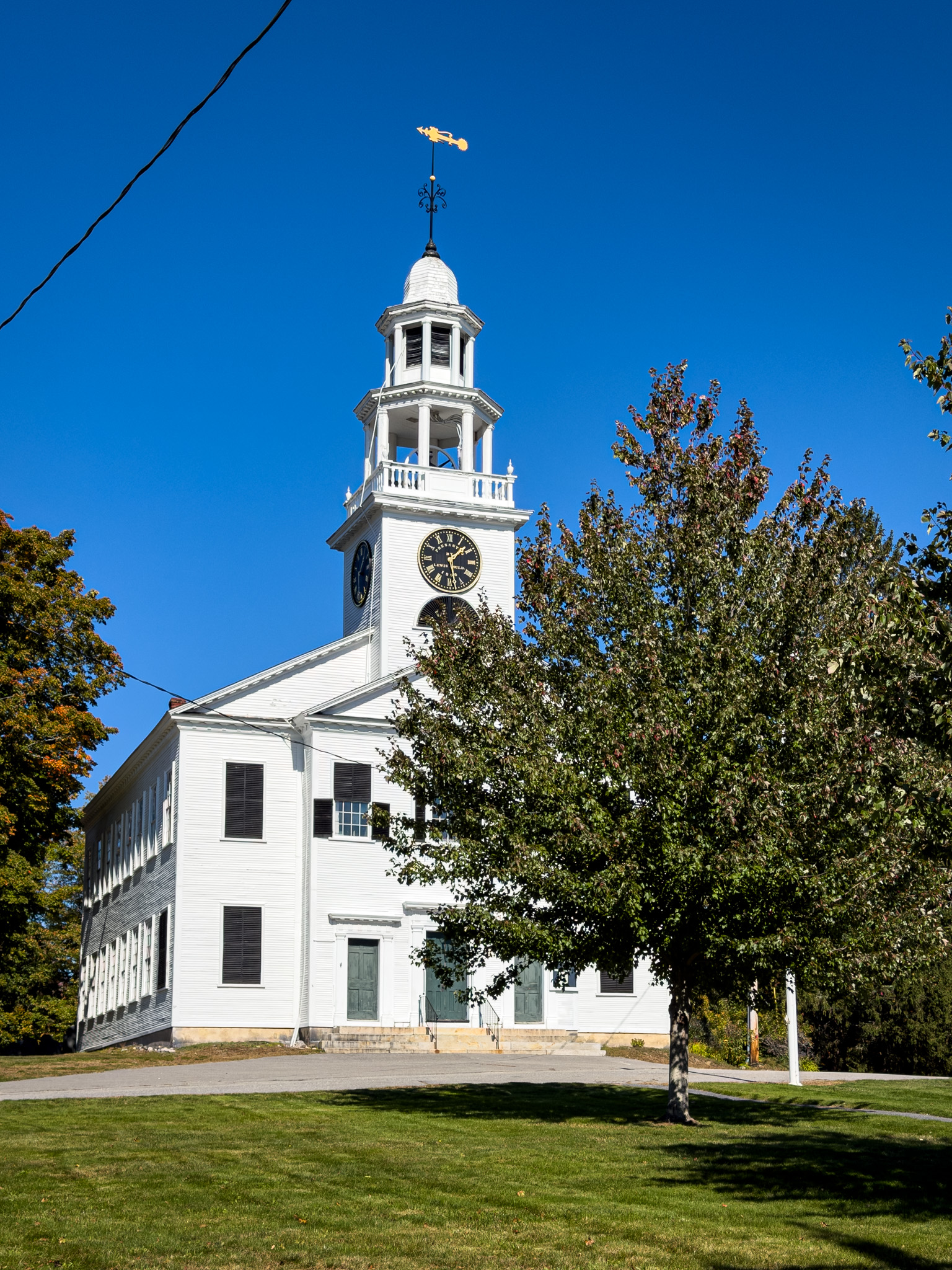 White meeting house with a steeple and clock in Ashby, Massachusetts