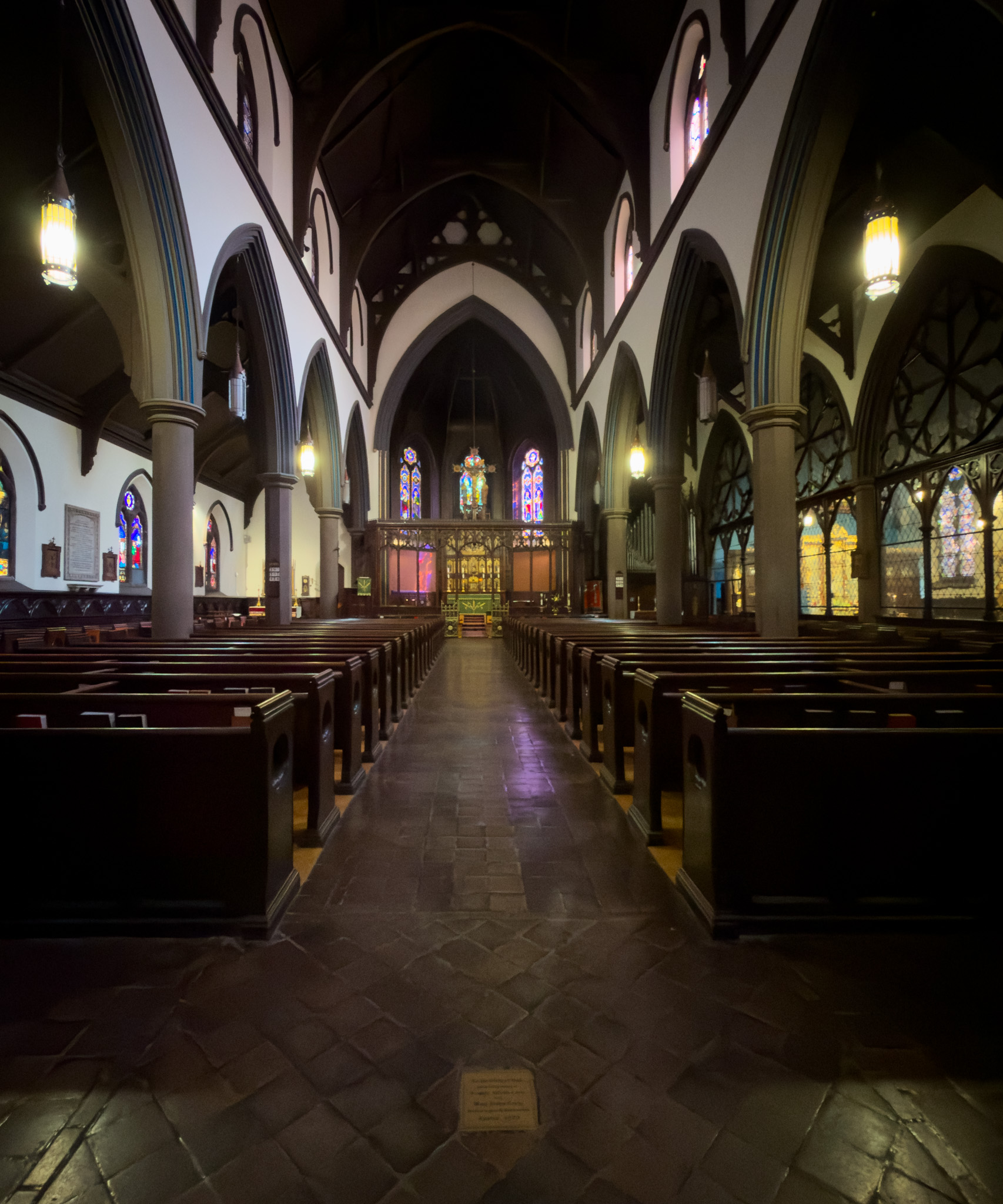 Nave of the stone church with rows of wooden pews