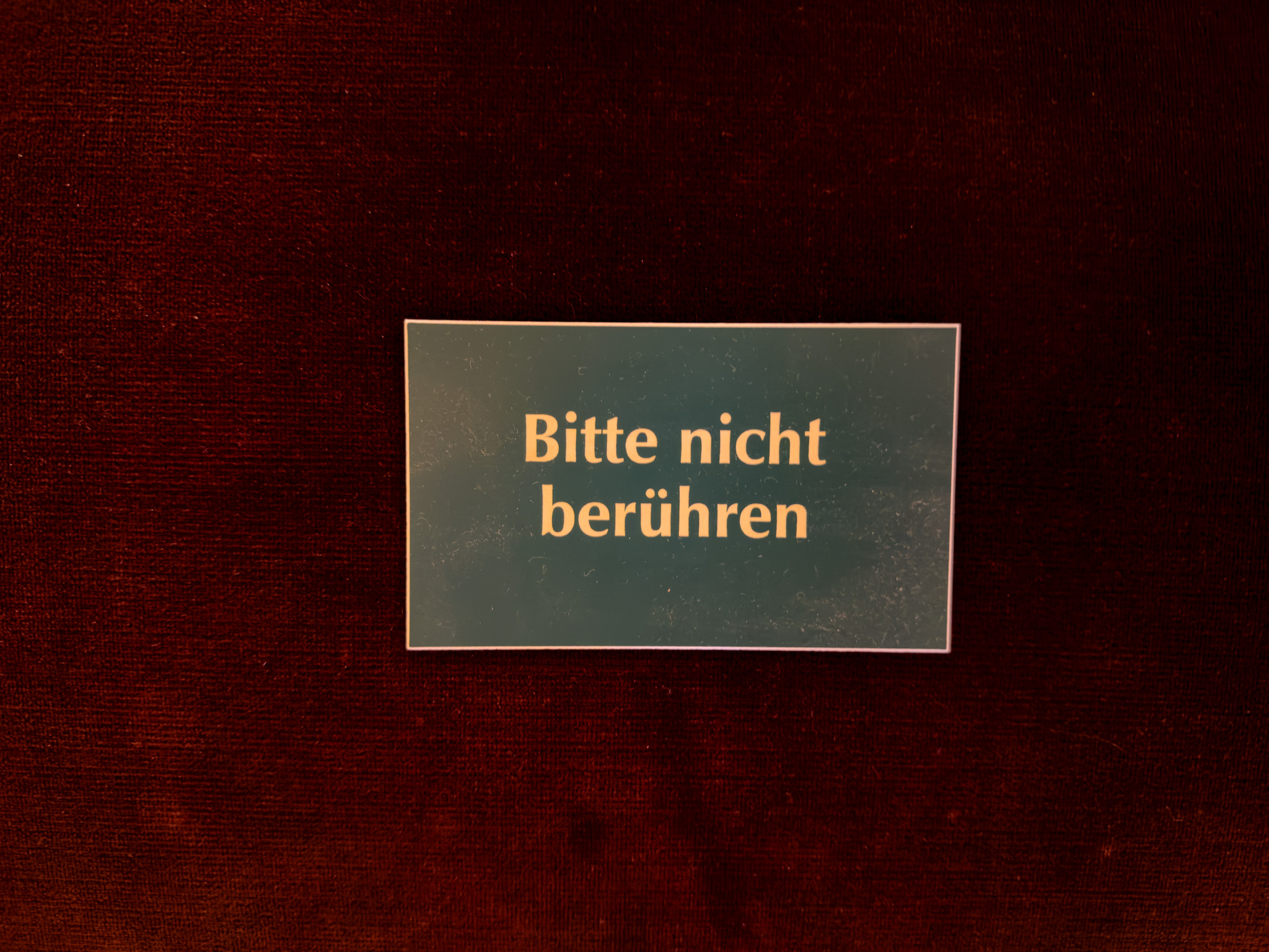 A Bitte nicht beruehren, do not touch, sign on red velvet