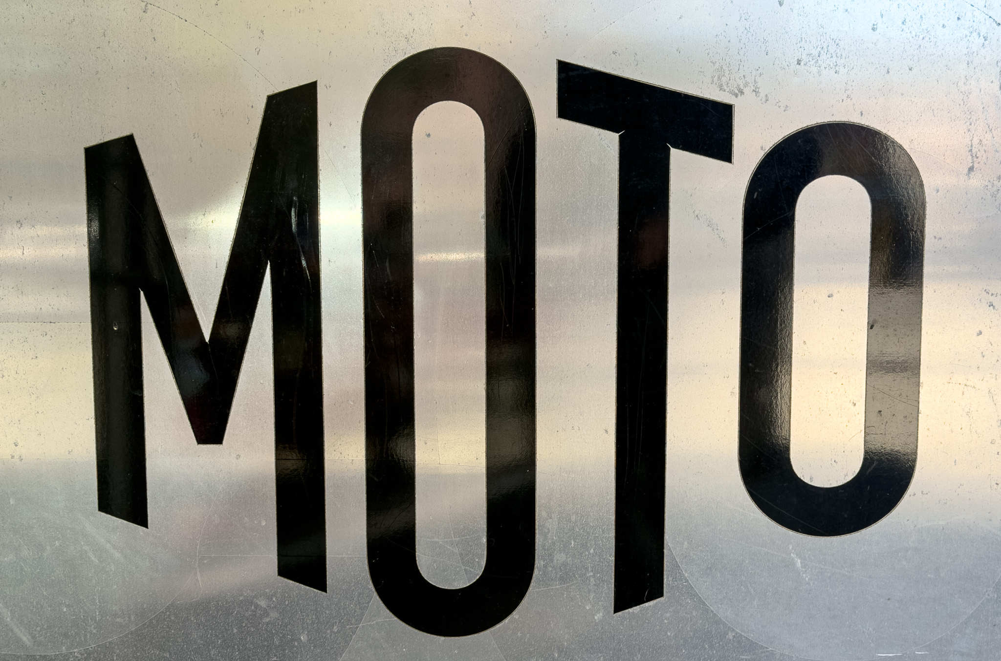 Black MOTO lettering on a frosted glass window