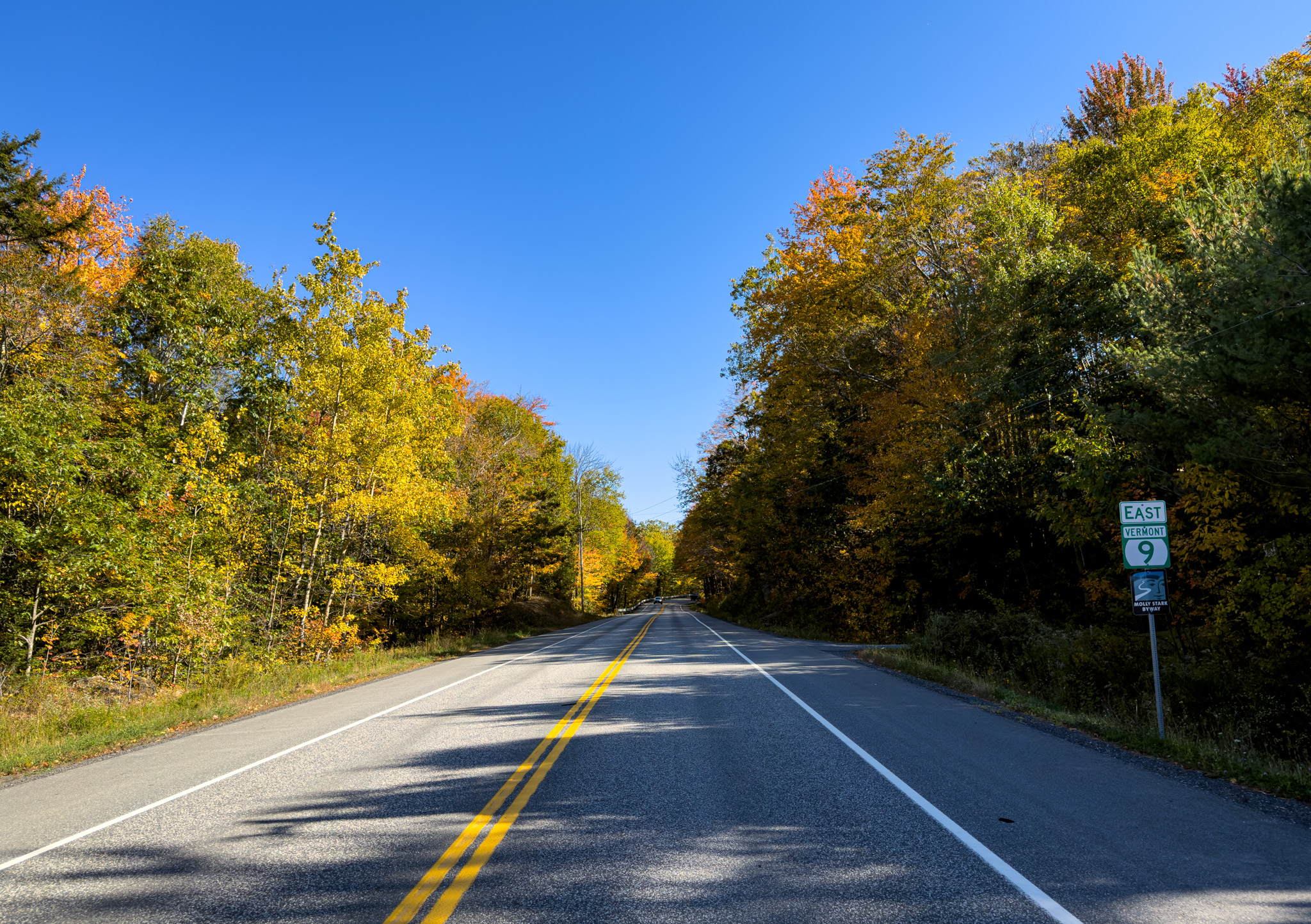 Vermont Route 9 East sign beside a road lined with yellow trees