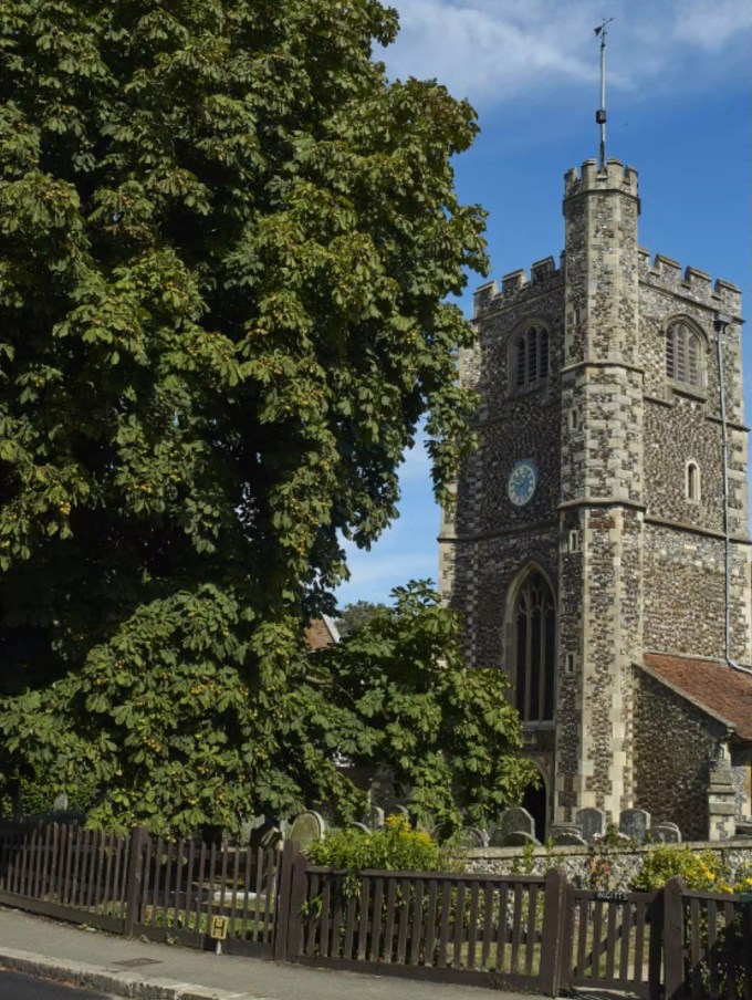Peaceful, rural-seeming scene of a stone-built church surrounded by trees under in Monken Hadley, Barnet, near London.