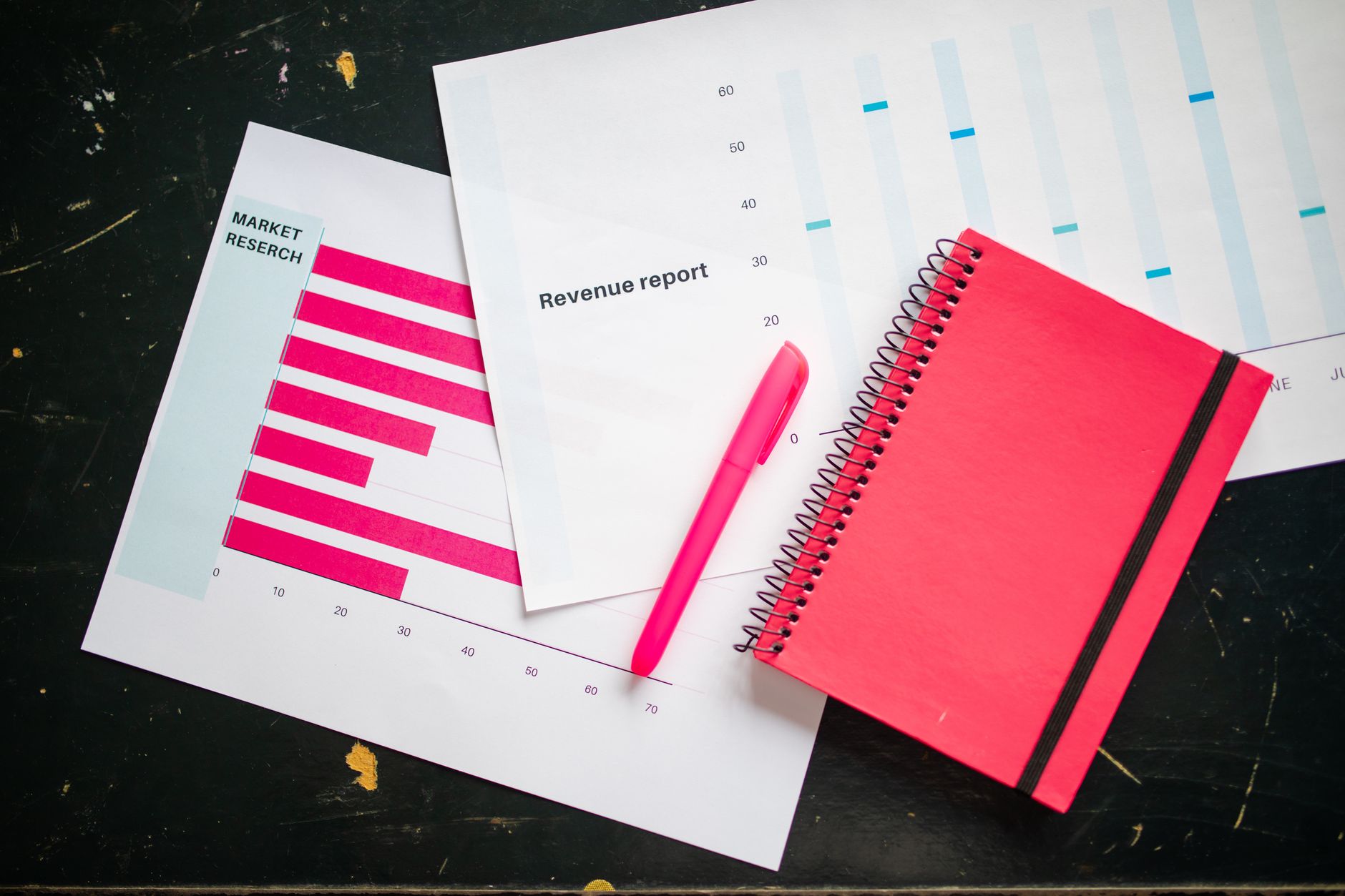 overhead shot of a pen and notebook on charts