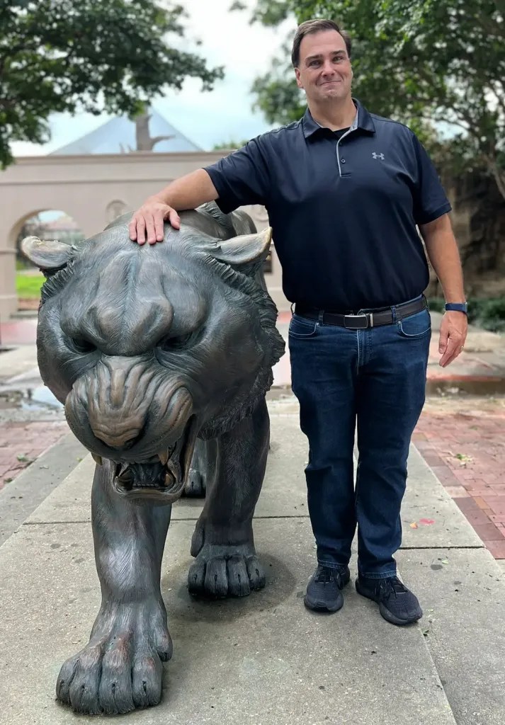 Full head to toe shot of Jason Romans and Mike the Tiger statue at LSU campus