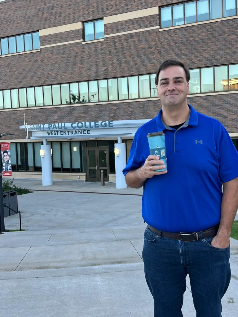 Jason Romans holding a coffee outside the Saint Paul College entrance at SQL Saturday Minnesota 2024