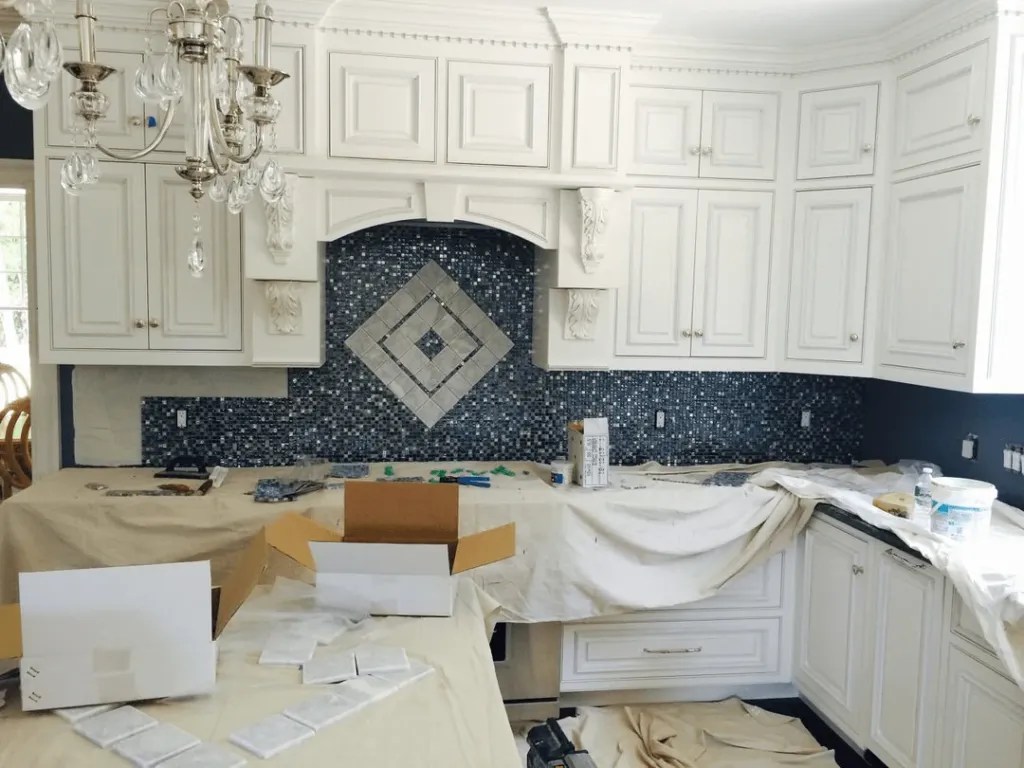 Kitchen backsplash tile installation in progress with detailed craftsmanship