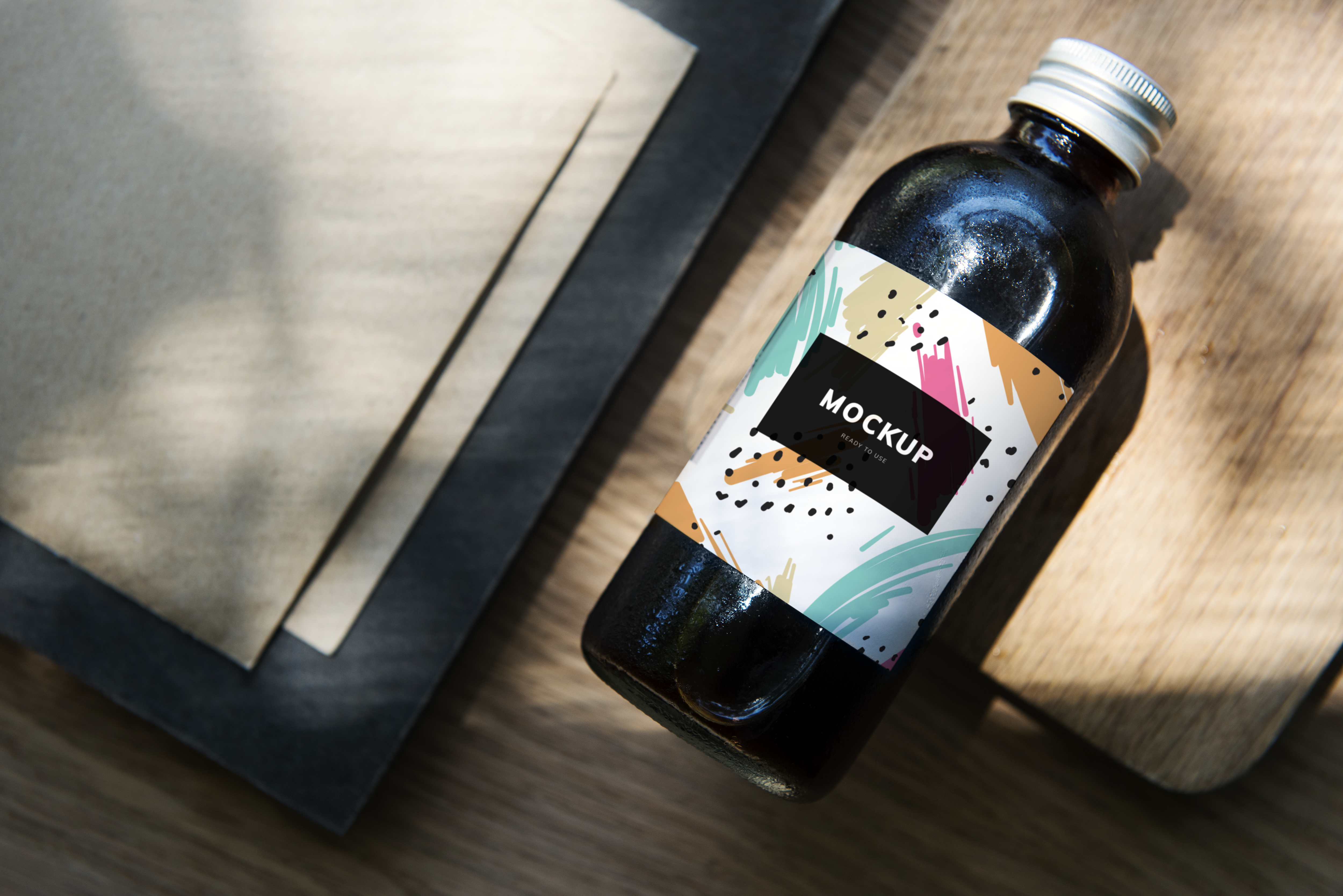 A picture of a dark bottle with a colorful label displaying the word mockup, indicating the importance of using an English copywriting service for product labeling