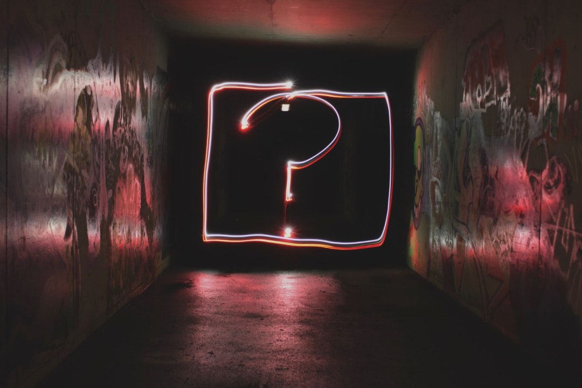 A picture of an underground pathway with a red neon question mark, representing questions you may have for an English copywriter and proofreader in Korea.