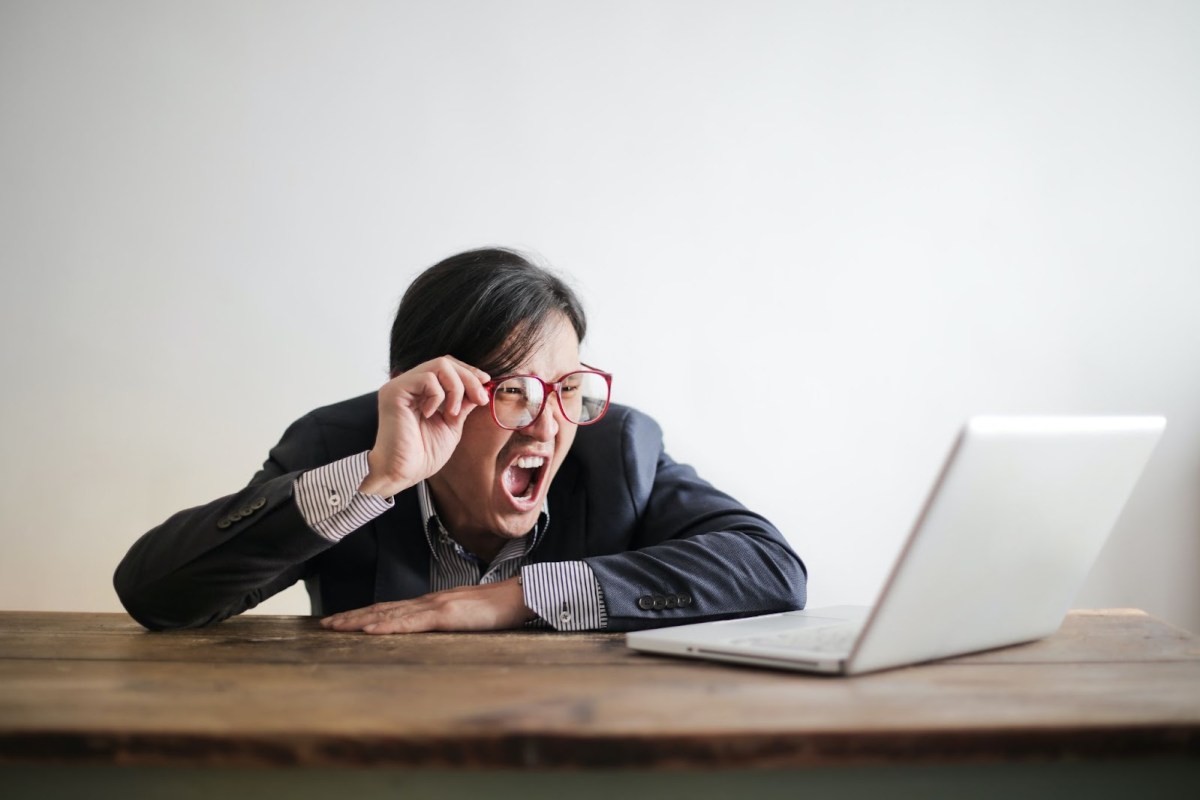 An Asian male screaming at a computer screen