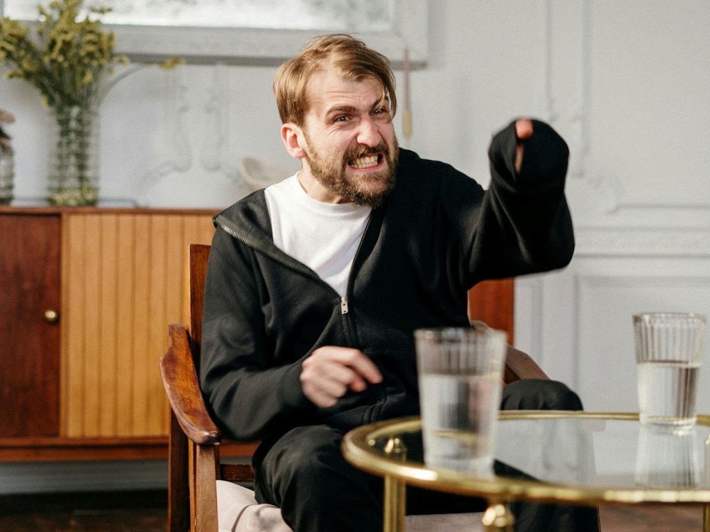 Angry man in a cafe pointing at the camera