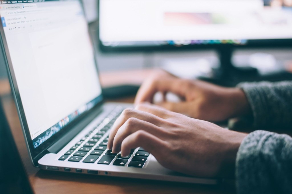 Close up of a freelance worker's hands typing on a computer